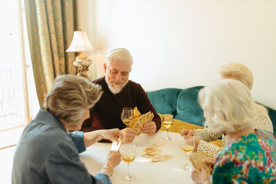Grupo de amigas jogando cartas em volta de uma mesa
