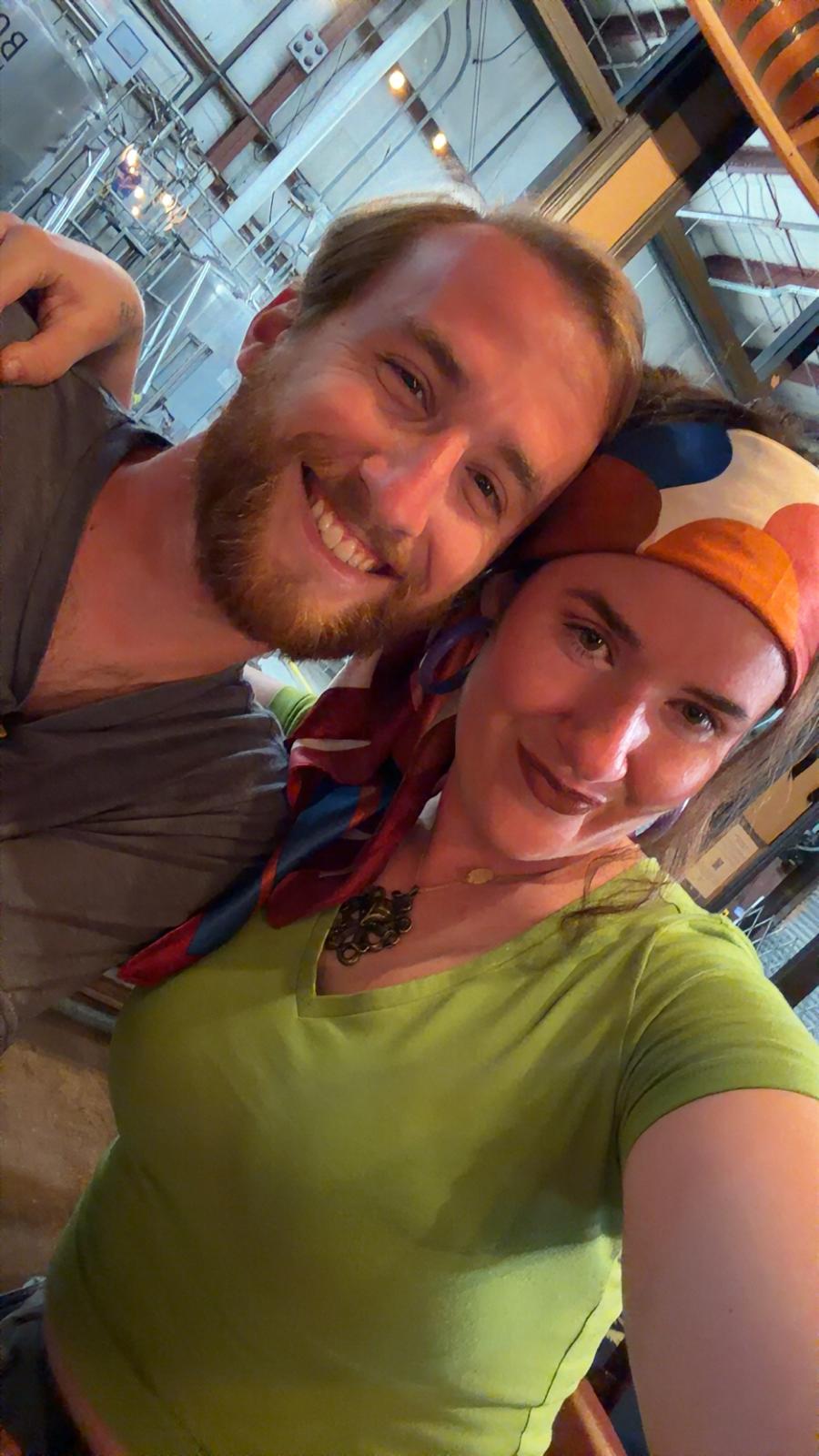 Caroline Moran e o companheiro, Jake, sorriem juntos numa selfie