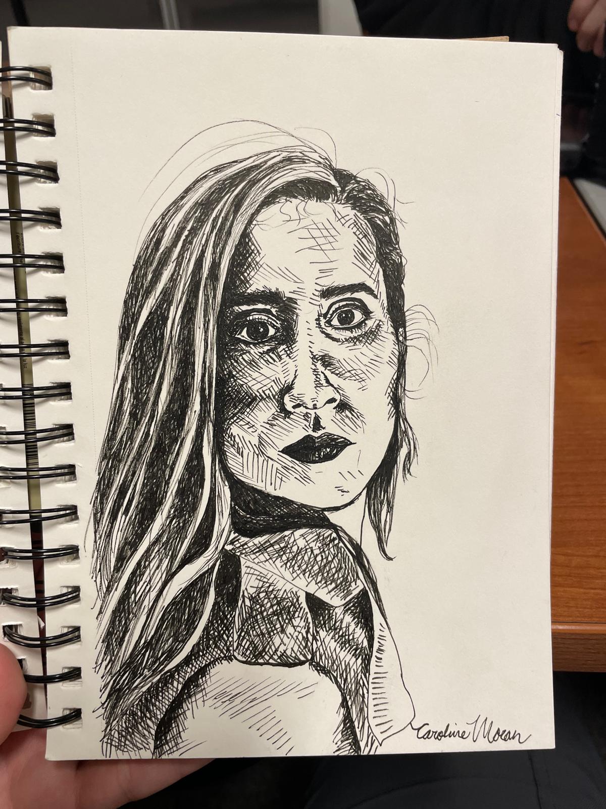 Retrato feminino desenhado a nanquim num caderno espiral, com a assinatura de Caroline Moran